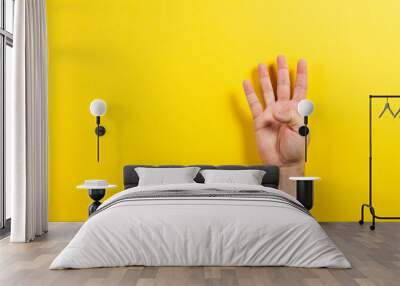 Man hand showing four fingers on yellow background. Number two symbol Wall mural