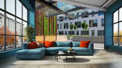 New office building and outdoors recreation area with modern city landscaping, concrete and wooden benches, green plants Wall mural