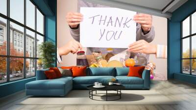 Thank you for donation. Volunteers holding paper sheet with message Thank you over food donation box full of glocery Wall mural