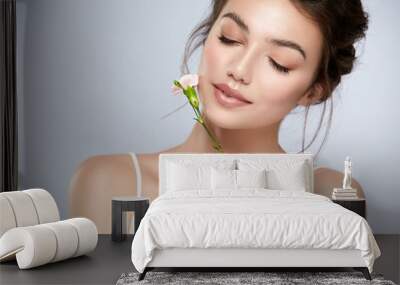 cute girl with perfect skin and white flower near face closed eyes Wall mural