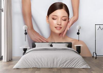 female hands doing massage for woman's face and shoulders, beautiful girl having spa theraphy for her body Wall mural