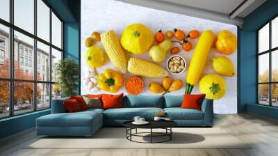 Assorted types of yellow food- vegetables, fruits, legume on white wooden background. Top view Wall mural