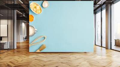 Baking background with  whisk, egg, flour , sugar, butter on blue table top view. Flat lay. Wall mural