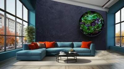 Mix fresh salad leaves in bowl on black background  Wall mural