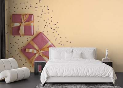 Two gift boxes with ribbon and bow on yellow background with  star confetti . Top view and space for text.	 Wall mural