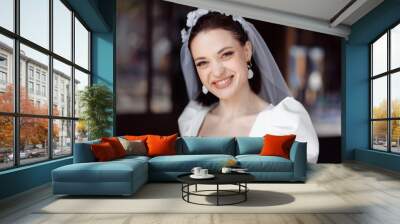 beautiful young woman bride happy on her wedding day in a white dress and veil. Wall mural