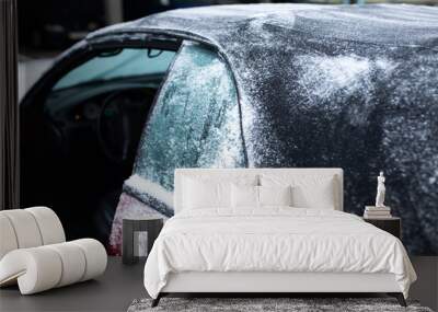 frozen glass and roof of a convertible car in winter, snow on the tarpaulin. Wall mural