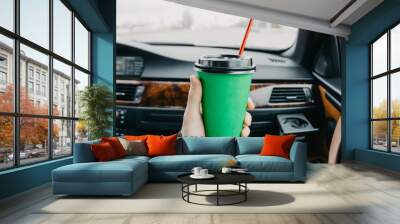 green cardboard cup of coffee in the car in the hands. drink on the go. Wall mural