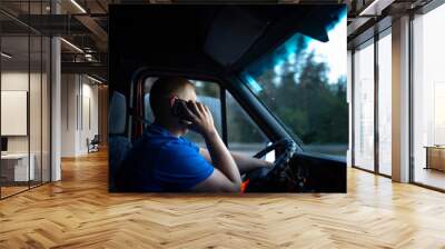 male truck driver is driving a truck and talking on the phone.
​ Wall mural