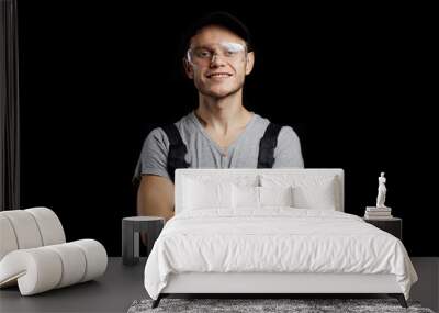 portrait of a working auto mechanic in glasses, a cap and overalls on a dark background. Wall mural