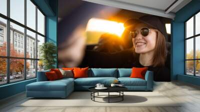 positive female driver driving a car in sunglasses, cool girl driving Wall mural