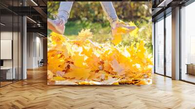 Girl kid jumping on trampoline with autumn leaves. Bright yellow orange maple foliage. Child walking, having fun, playing in fall backyard. Outdoor funny happy season family activity in autumn park Wall mural