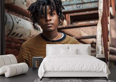 Young handsome stylish black man with natural hair dreadlocks. Afroamerican guy.Stairs,wall painted with graffiti in poor quarter of street art culture city district.African american skateboarder man Wall mural