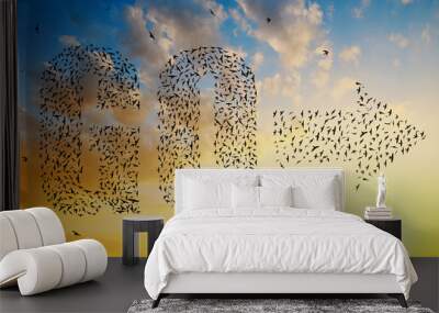 Silhouette of birds flying in text go and arrow formation at sunset sky. Wall mural