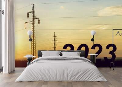 The number 2023 with electric pylons at sunset. Concept of high price of electricity or Happy New Year. Wall mural