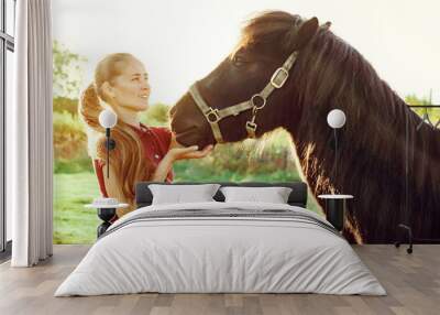 young beautiful girl strokes horse Wall mural