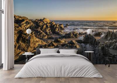 Beautiful vibrant sunset landscape image of calm sea against roc Wall mural