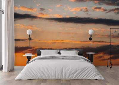 a fabulously beautiful summer sunset. dark clouds in yellow and orange colours. the sun's rays from  Wall mural