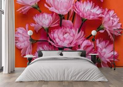 pink flowers on orange background flat lay top view Wall mural