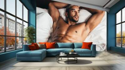 Sexy man in bed in hotel room Wall mural