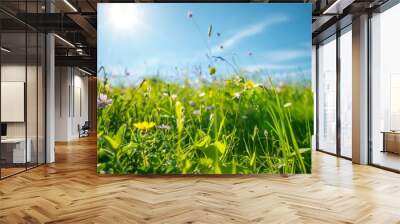 Lush green meadow with wildflowers under a clear blue sky Wall mural