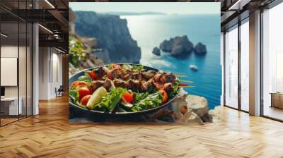 Vegetable salad and souvlaki on skewers in front of the sparkling blue sea during summer Wall mural