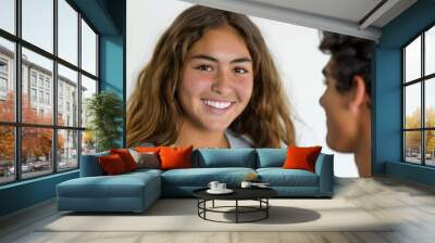 A young woman and man communicate with sign language on a white backdrop, both with big smiles Wall mural