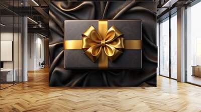 Black and gold gift box with ribbon on black silk fabric. Wall mural