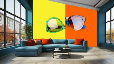 two sunglasses yellow orange red background closeup top view, fashion man and woman sunshades, pair  Wall mural