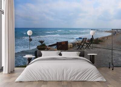 Seascape in Kokkini Hani, Crete, Greece. A table and two chairs on a deserted beach.  Scenic sea view landscape in the evening. Wall mural