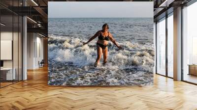 Woman in a swimsuit standing in the sea Wall mural