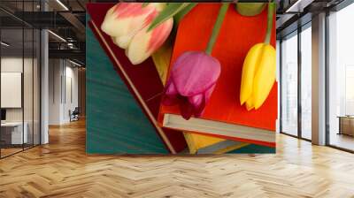 Flowers tulips and books on a blue wooden table Wall mural