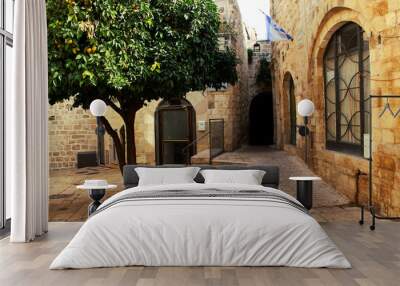 Orange tree on the street in the center of the old city of Jerusalem. The street is Jerusalem. Wall mural