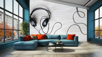 Black acoustic headphones on light wood table background. Top view. Flat lay. Wall mural