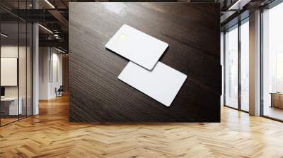 Photo of two blank credit cards on wood table background. White bank cards. Wall mural