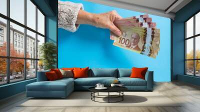 Banknotes of Canadian currency: Dollar. Overhead of senior person holding bills. Wall mural