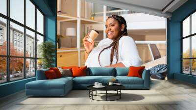 Joyful african american woman drinking coffee in the office. Candid, cbreak, relaxation concept.. Wall mural