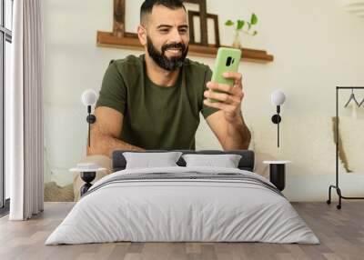 man with partial hand amputation smiling and looking at cell phone screen. Wall mural