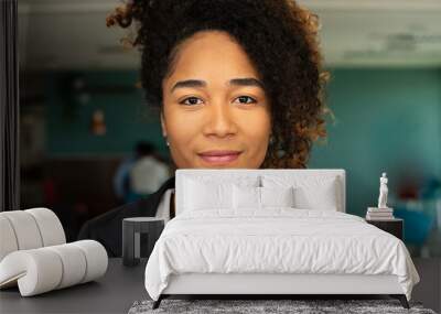 Portrait of black business woman looking at camera in the office. . Wall mural