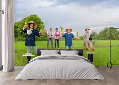 group of asian female farmers holding young rice sprouts,working in rice field,mature man,professional researcher interview young man smart farmer in paddy field,concept rice cultivation,rice research Wall mural