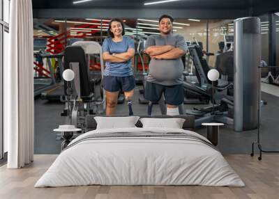 portrait persons with prosthetic leg standing arms crossed in gym fitness club Wall mural