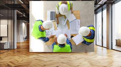 top view of engineers team meeting and discussing by using laptop,blueprint and documents on table in the building under construction,project manager consultation meeting with coworker Wall mural