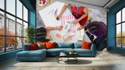 top view young female fashion designer and tailor discussing clothing design to woman customer with fashion sketch and color sample (selective focus), concept of business,industry,design,tailoring Wall mural