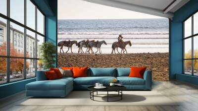 Two Costa Rican cowboys leading 4 horses along the beach in Jaco, Costa Rica 
 Wall mural