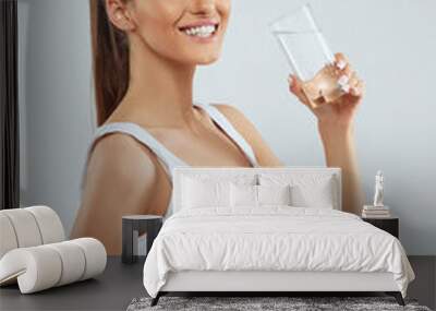 Beautiful woman holding water glass. Drink water. Girl with glass of water. Diet concept. Wall mural