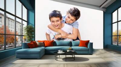 Two boys piggyback having funn and hugging Wall mural