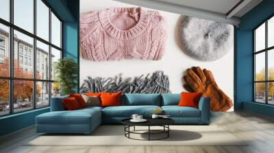 Flat lay with handmade knitted sweater, beret hat, woolen scarf and suede gloves on white background. Warm clothing. Autumn and winter basics Wall mural