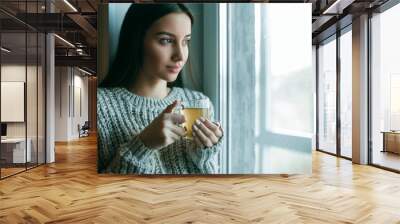 Beautiful woman drinking morning tea behind window Wall mural