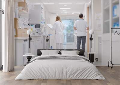 A healthcare professional and nurse are seen in modern hospital corridor, engaged in their duties. bright, sterile environment reflects commitment to patient care and professionalism Wall mural