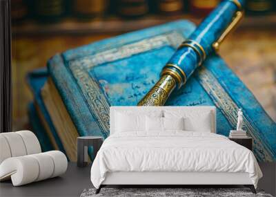 A blue and gold fountain pen rests on a worn blue book. Wall mural